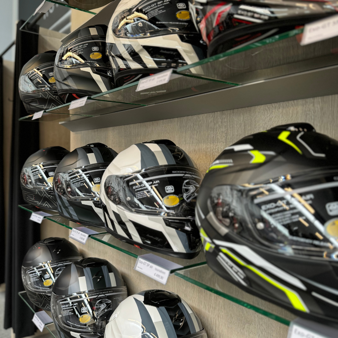 Overzicht van een schap vol motorhelmen van Scorpion bij EKO Motorwear in de winkel