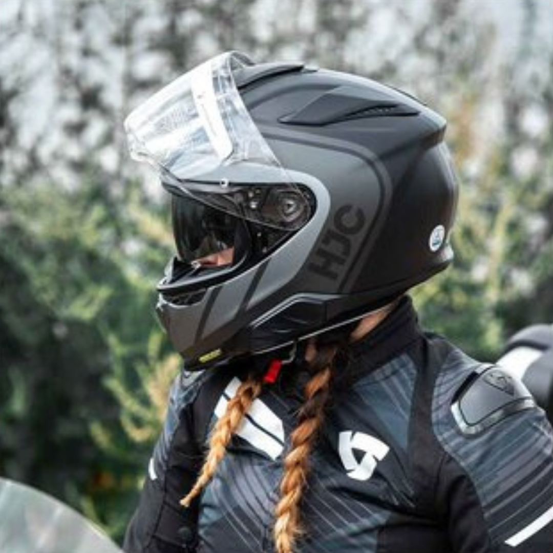 Vrouwelijke motorrijdster kijkt naar rechts en heeft HJC RPHA 71 Integraal motorhelm aan